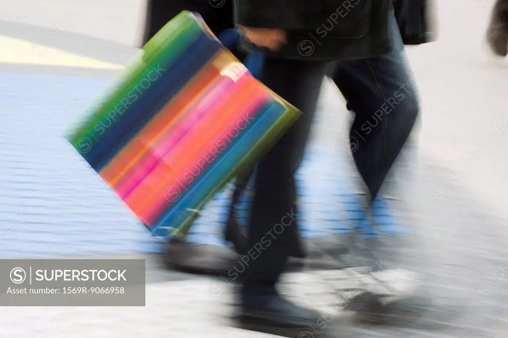 Pedestrian carrying shopping bag, blurred