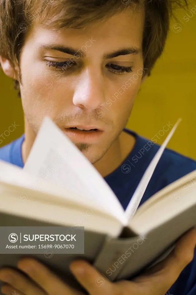 Young man reading book, close_up