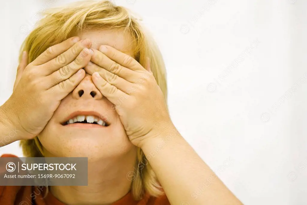 Boy covering eyes with hands