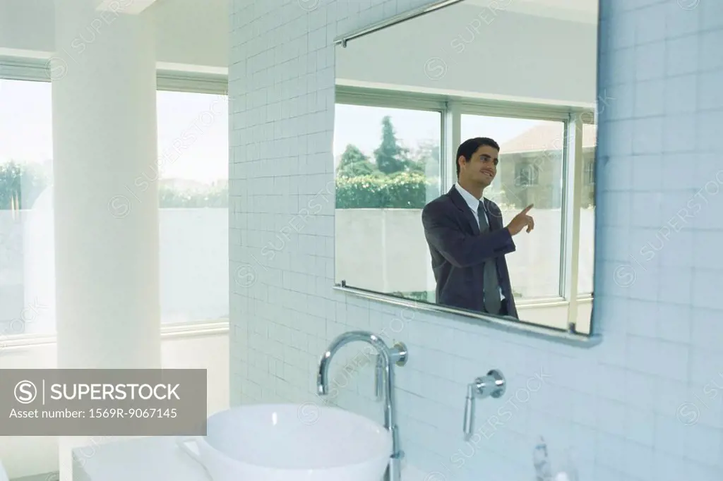 Businessman in bathroom having conversation with person out of frame
