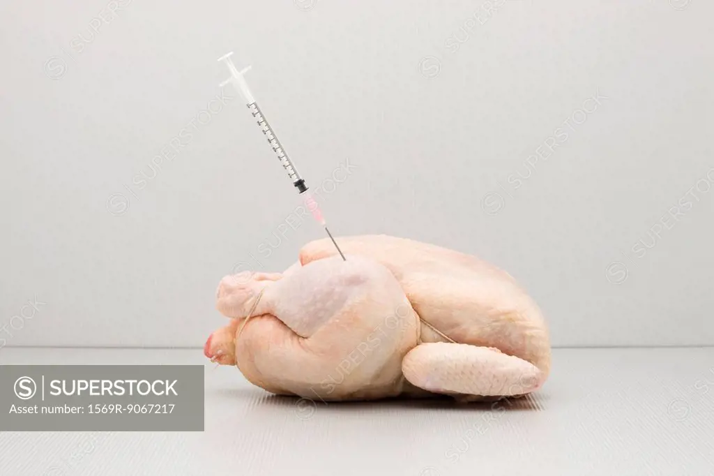 Food concept, syringe sticking out of raw chicken