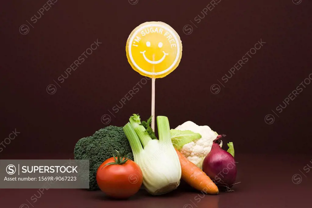 Food concept, pile of fresh vegetables with sugarfree lollipop