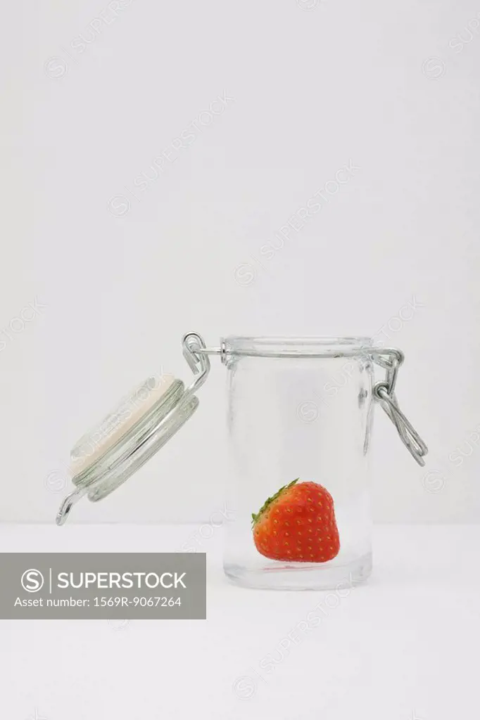 Food concept, single fresh strawberry in glass gar