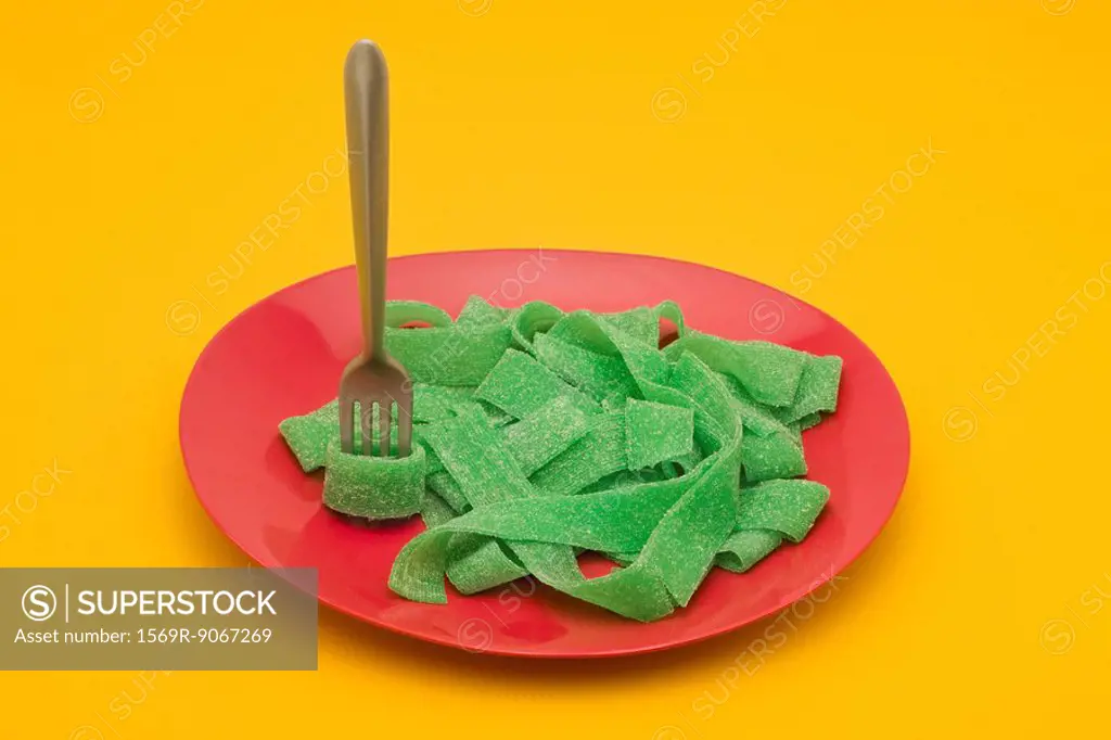 Food concept, plate of green gummy candy arranged like pasta