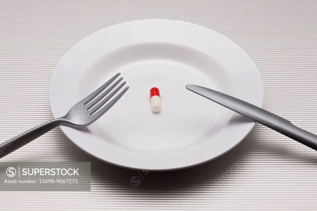 Food concept, single pill on plate