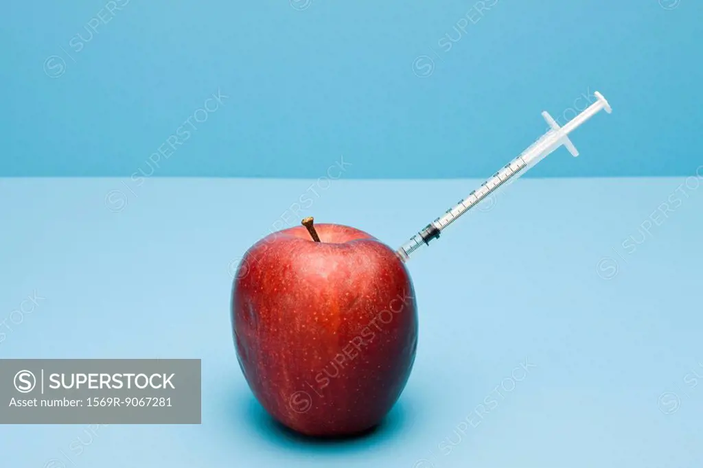 Food concept, syringe sticking out of apple
