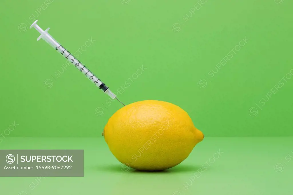 Food concept, syringe sticking out of lemon