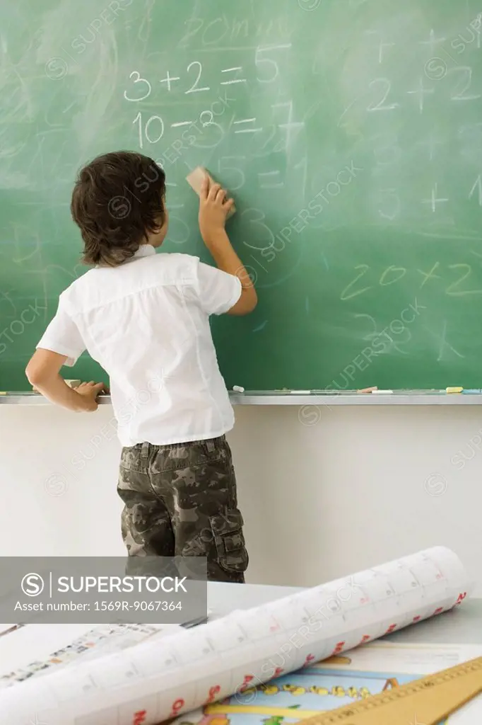 Boy erasing blackboard, rear view