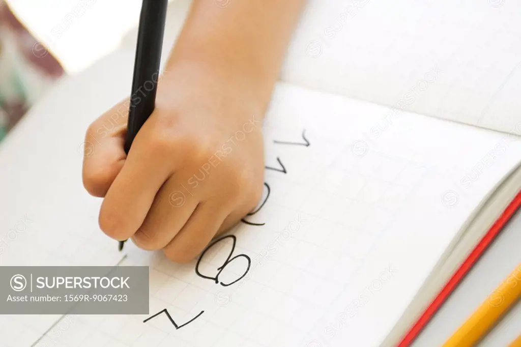 Child´s hand writing in notebook