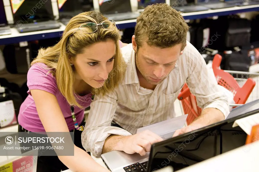 Couple shopping together for laptop computer