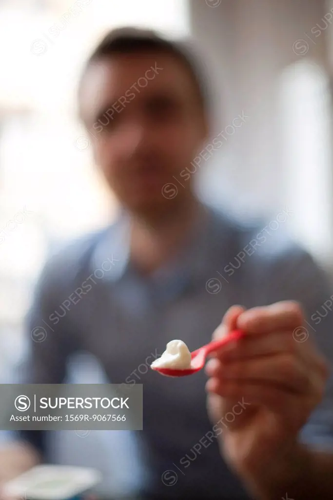 Person holding out spoonful of food, personal perspective