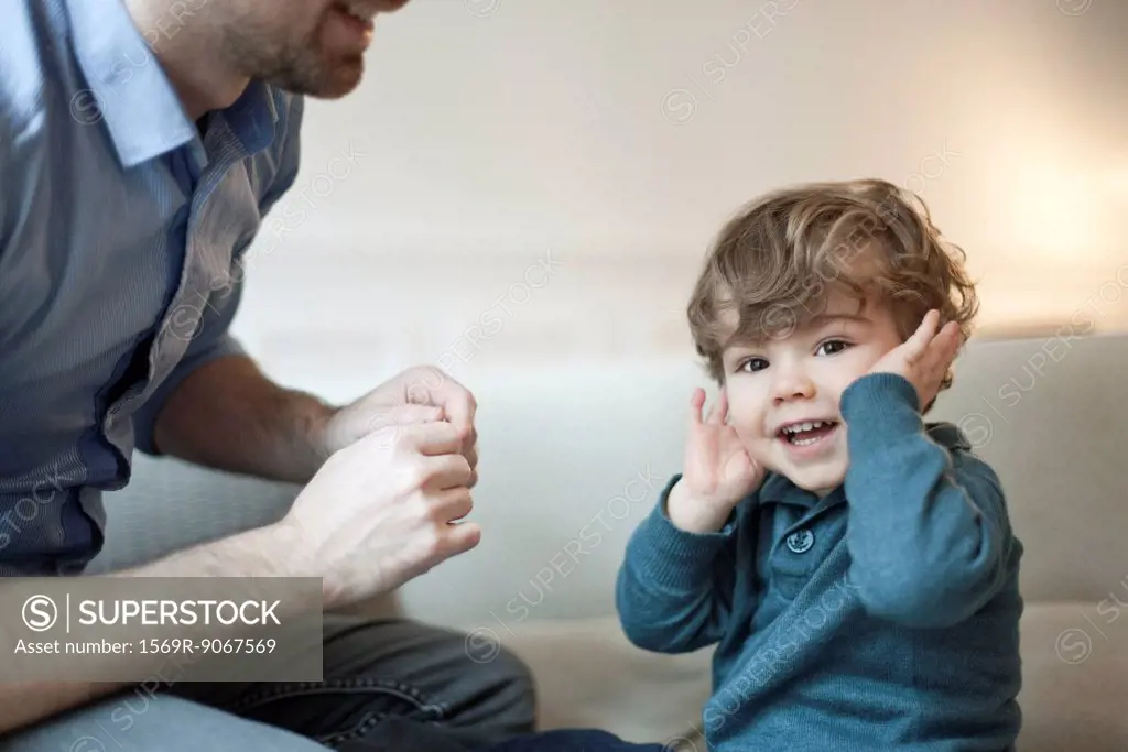 Toddler boy playing with father, portrait