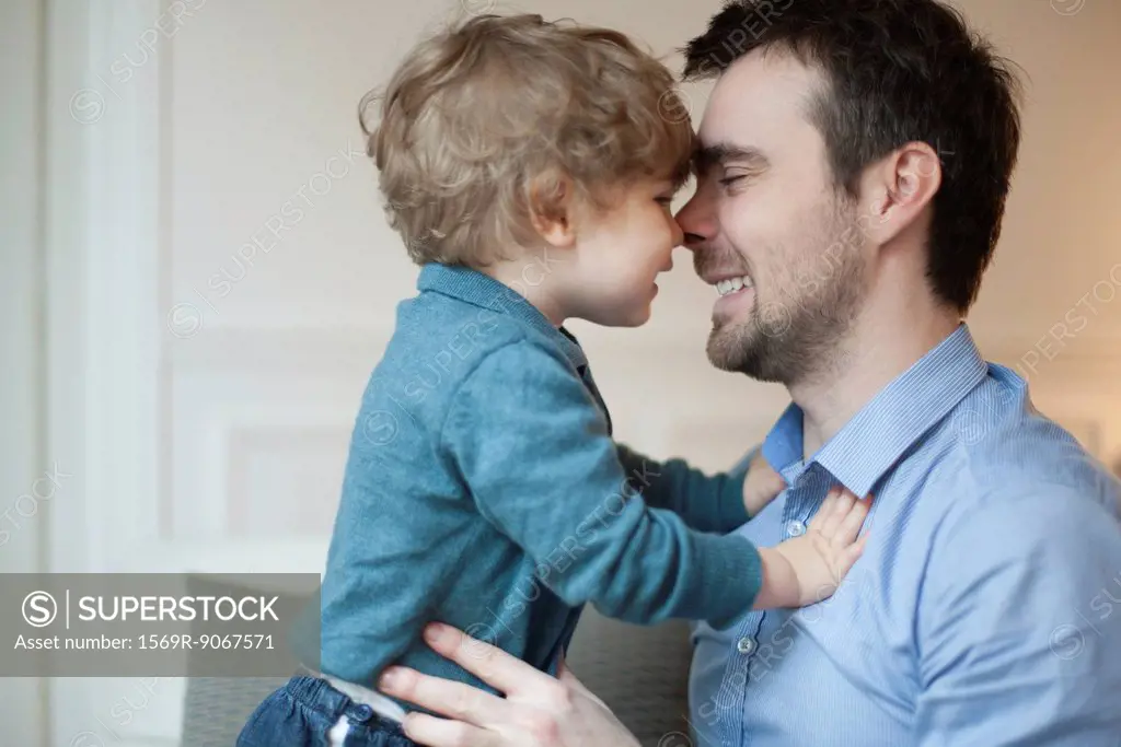 Father and toddler son nuzzling