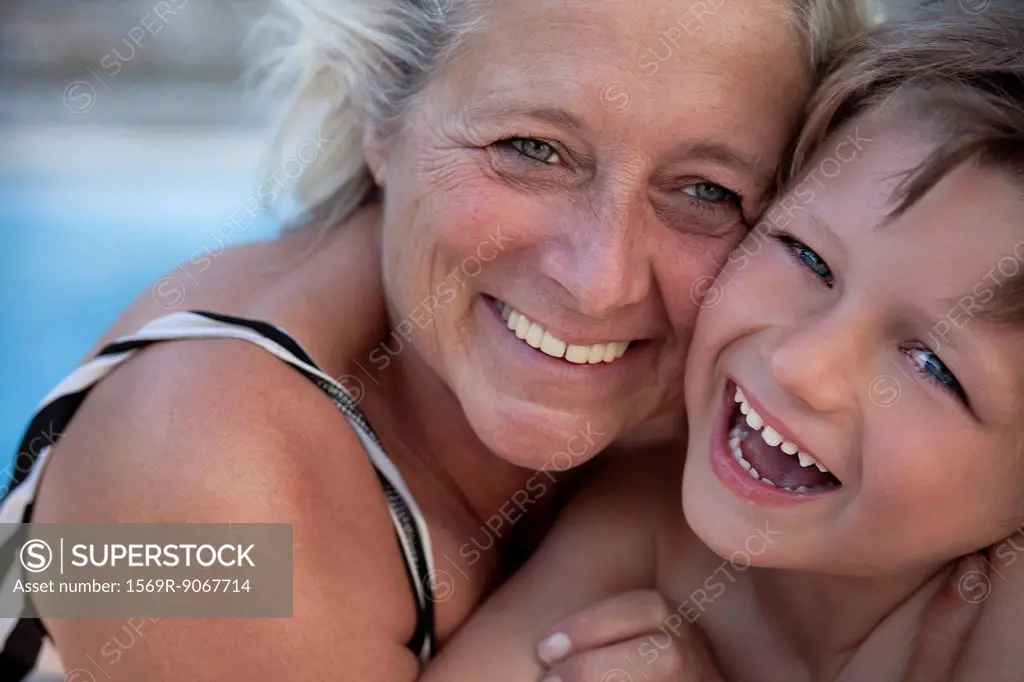 Grandmother and grandson laughing together outdoors, portrait
