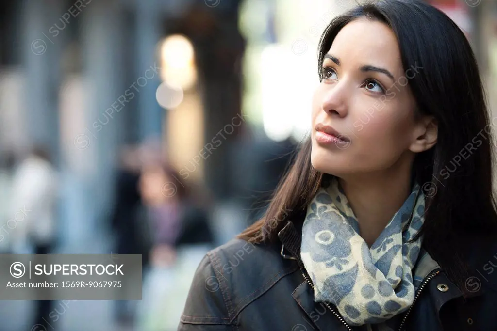 Woman outdoors, looking up, portrait