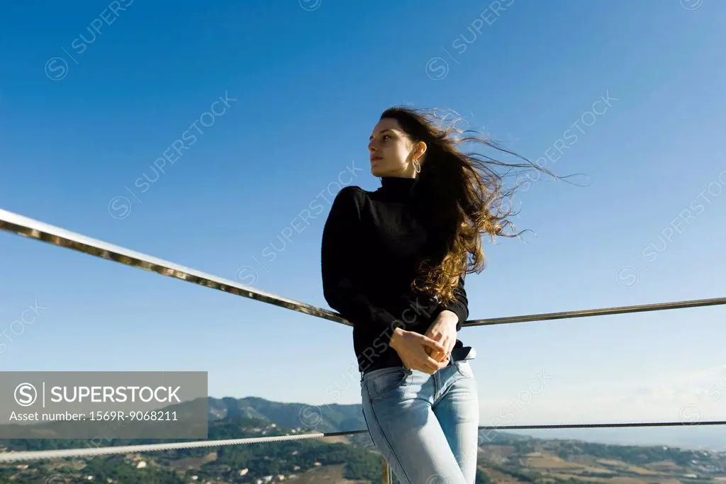 Woman leaning against railing, looking at view