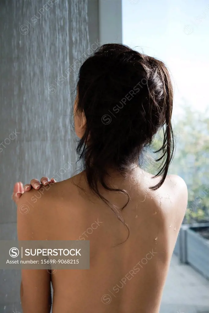 Woman taking a shower, rear view