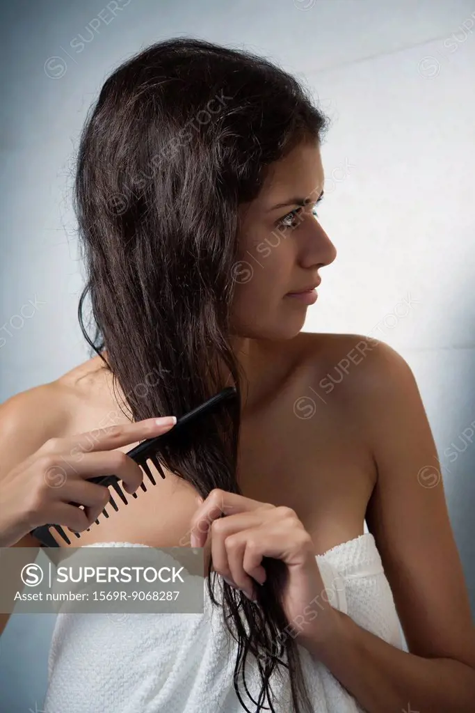 Woman combing her hair after a shower