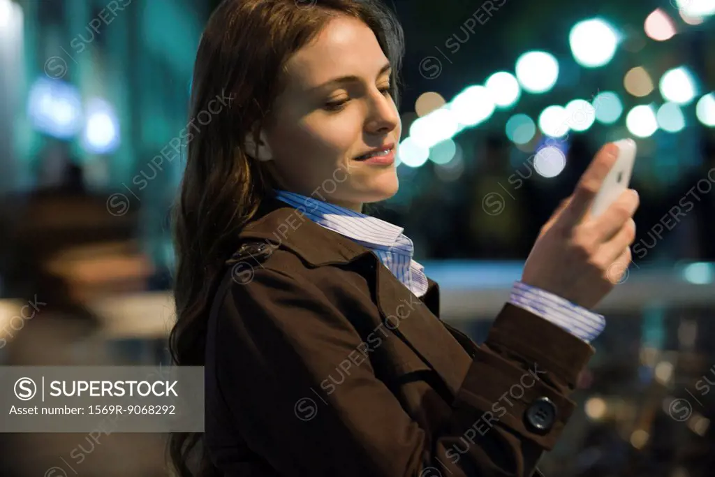 Woman text messaging outdoors at night