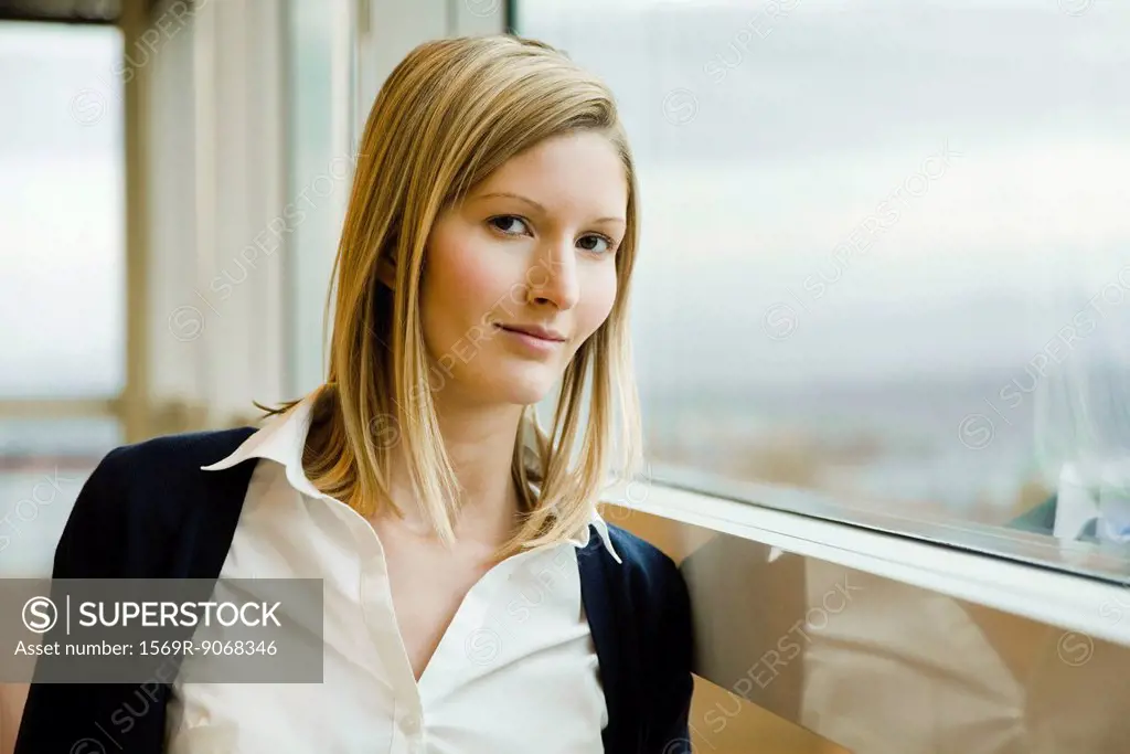 Woman leaning against window, portrait