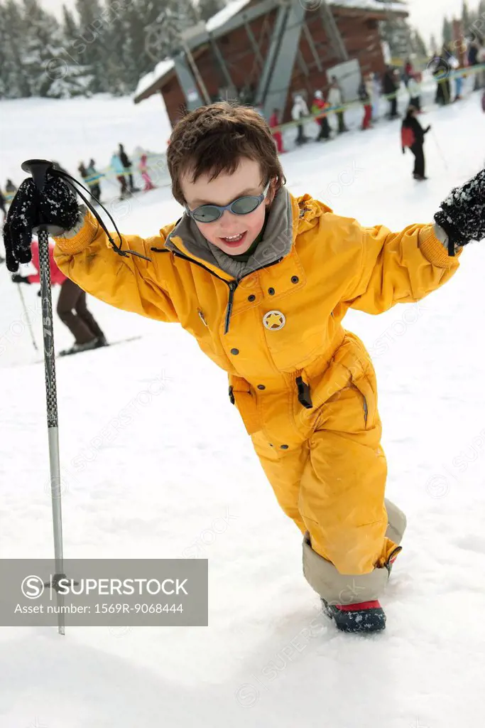 Little boy walking up ski slope