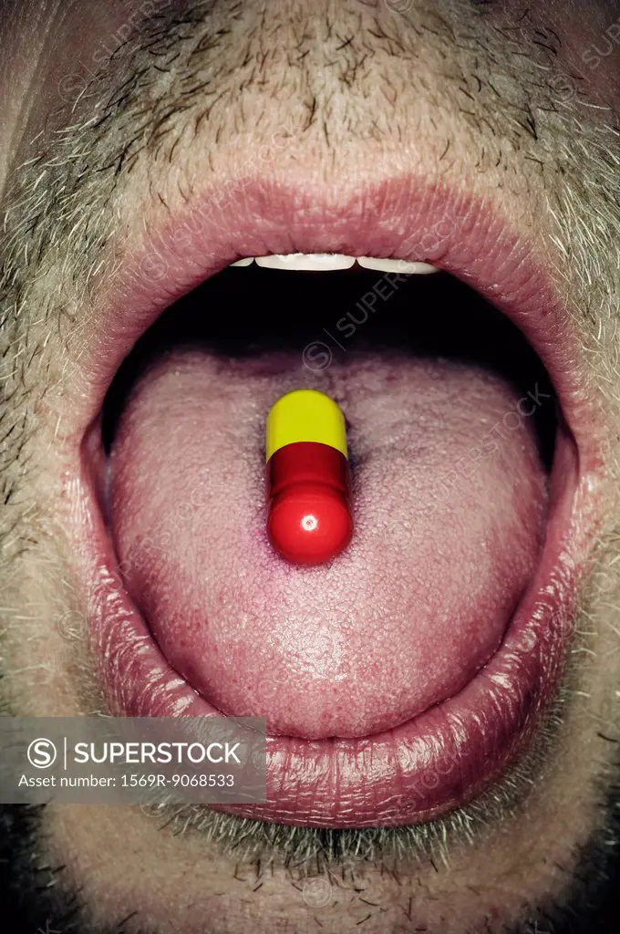 Capsule on man´s tongue, close_up