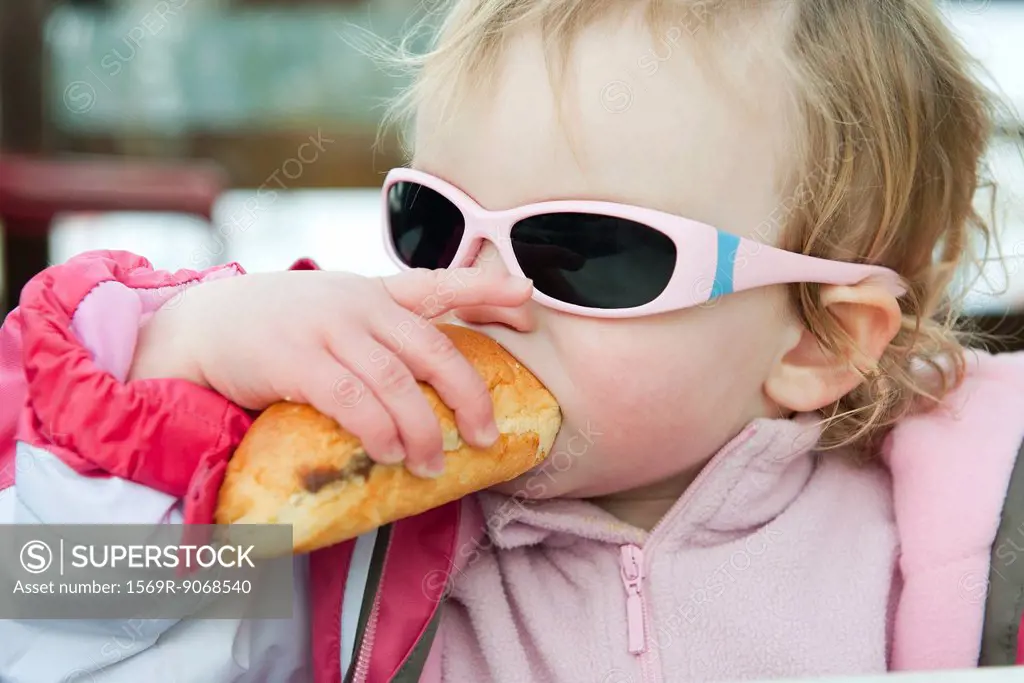 Toddler girl eating baguette