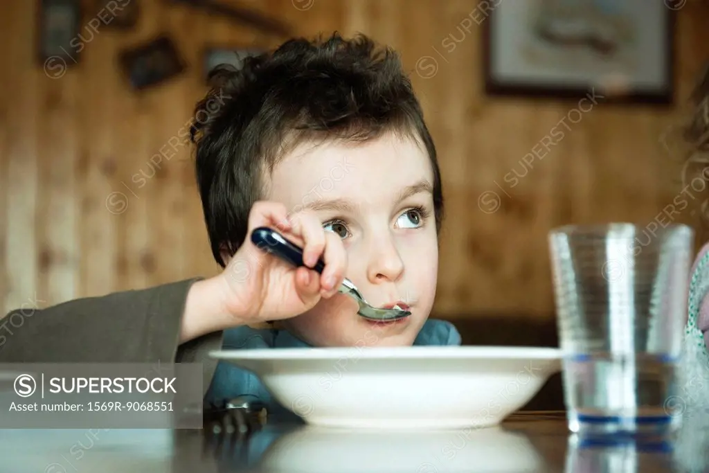 Little boy sitting at table eating