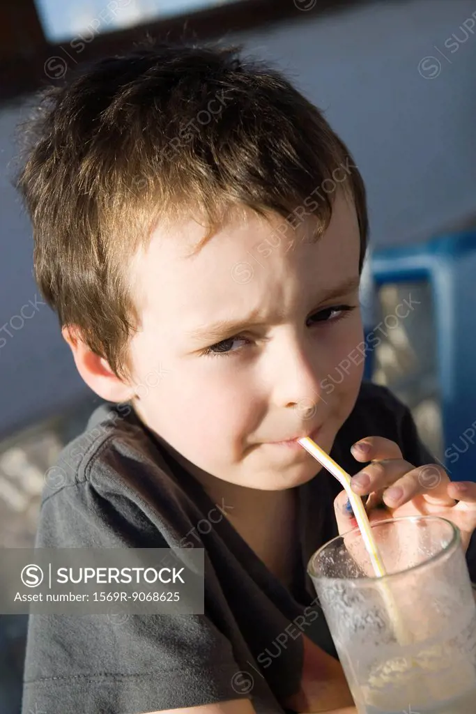 Boy drinking through straw, portrait