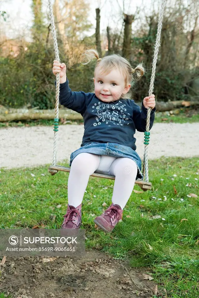 Toddler girl on swing, portrait