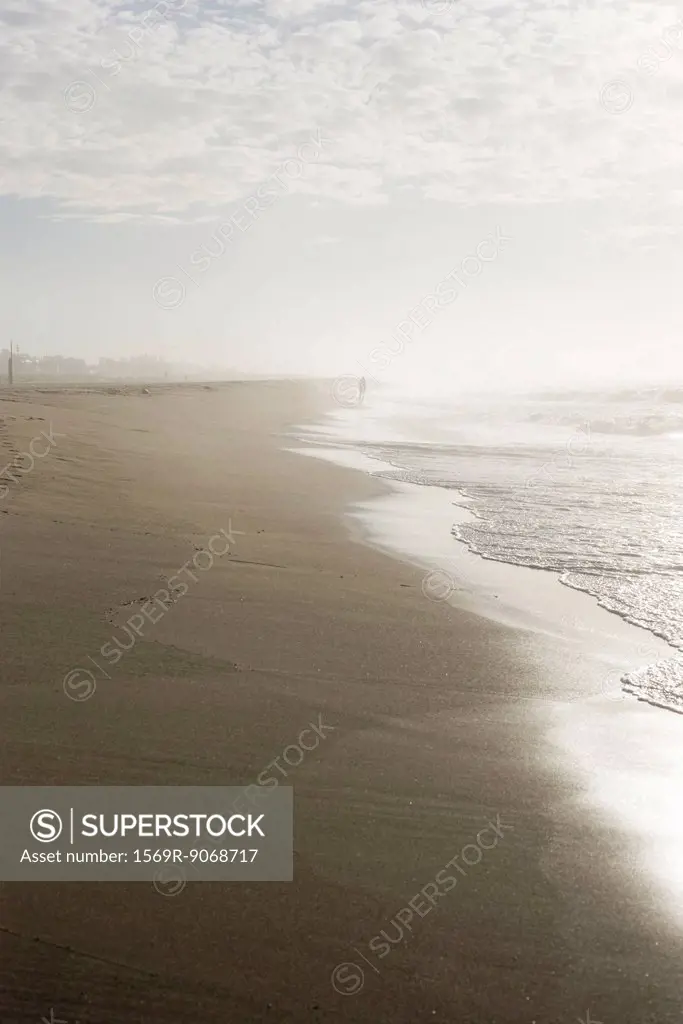 Person walking along beach in the distance