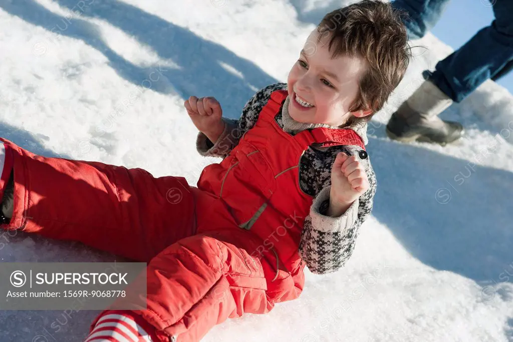 Boy sitting in snow, smiling