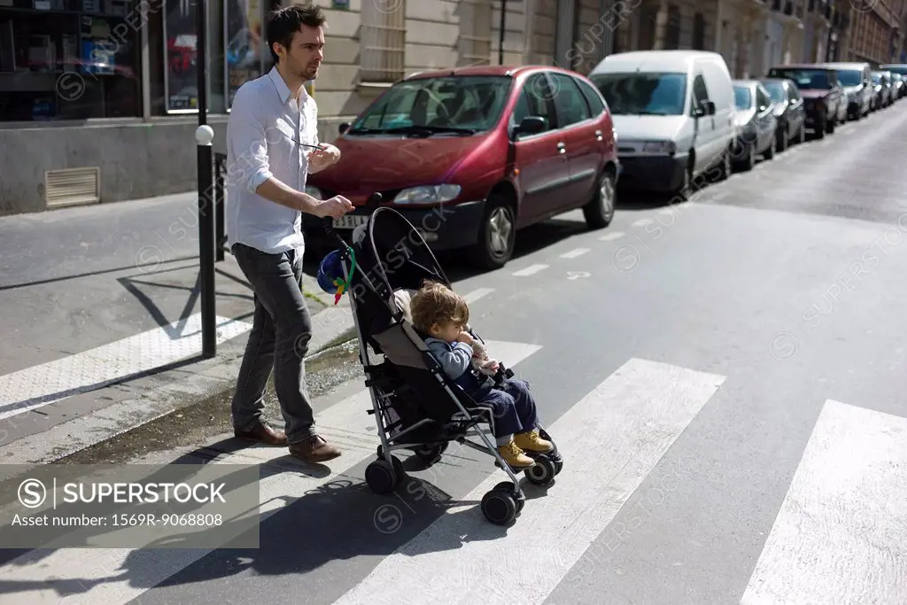 Father pushing toddler son in stroller