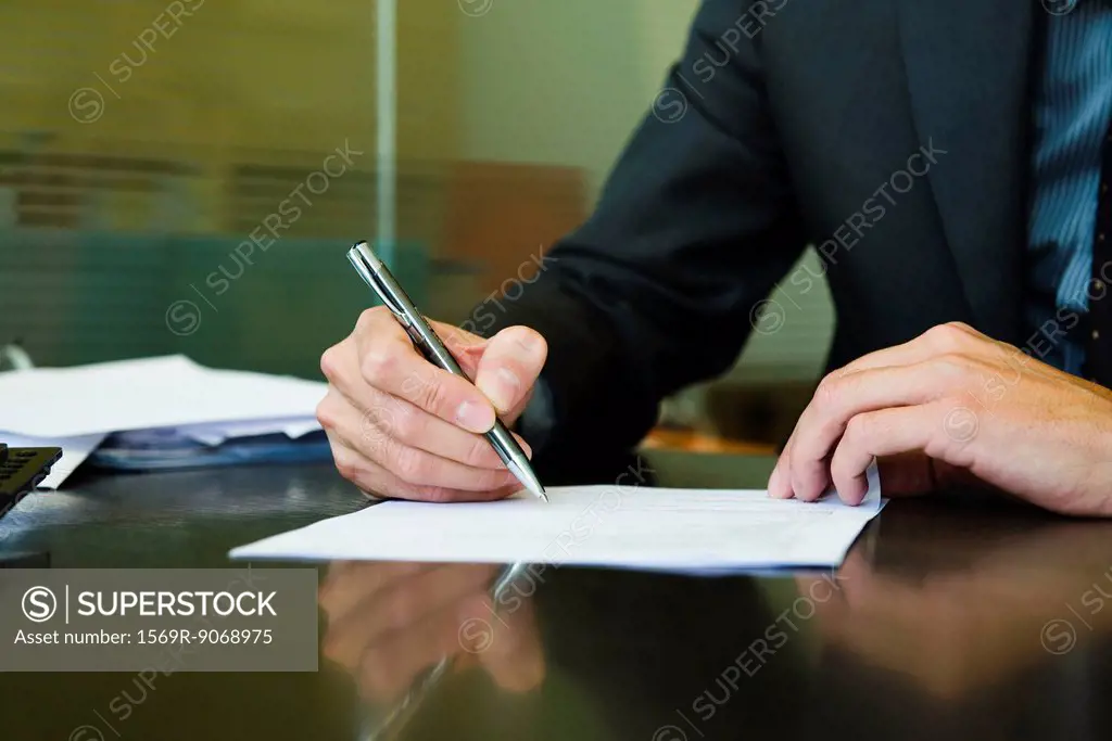 Executive signing paperwork, cropped