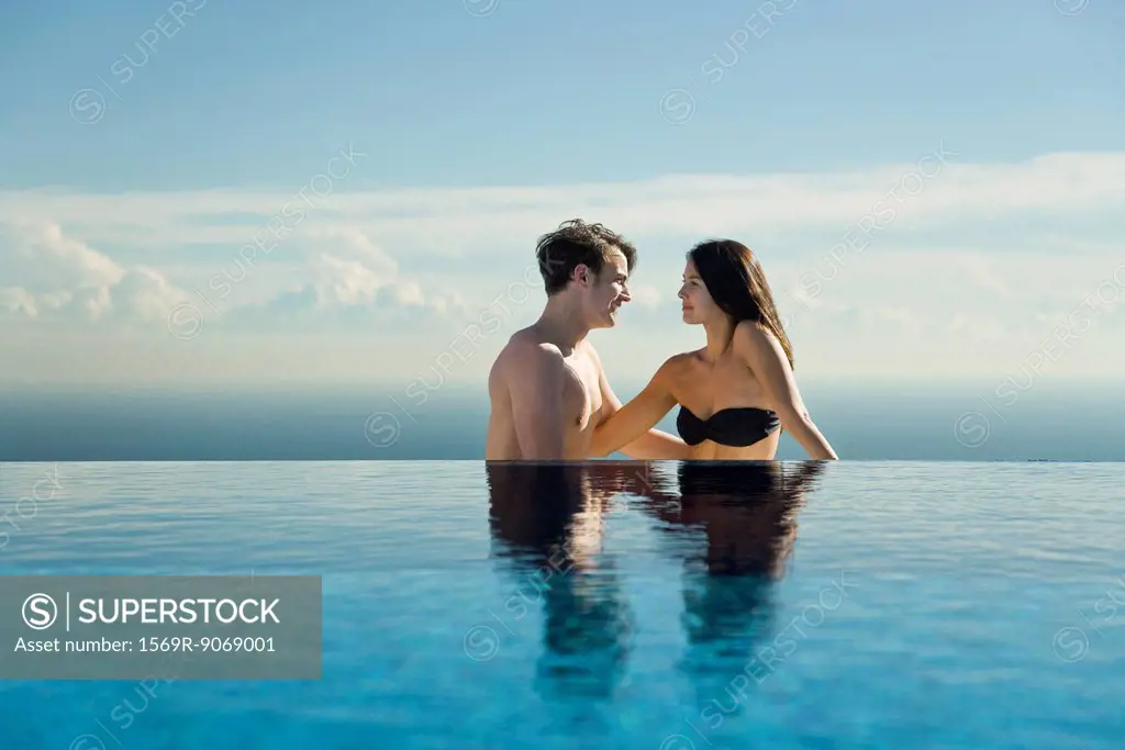 Couple relaxing by infinity pool