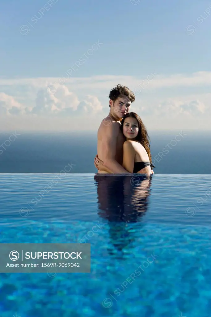 Young couple embracing at edge of infinity pool