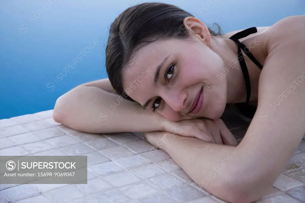 Woman lying beside pool, portrait