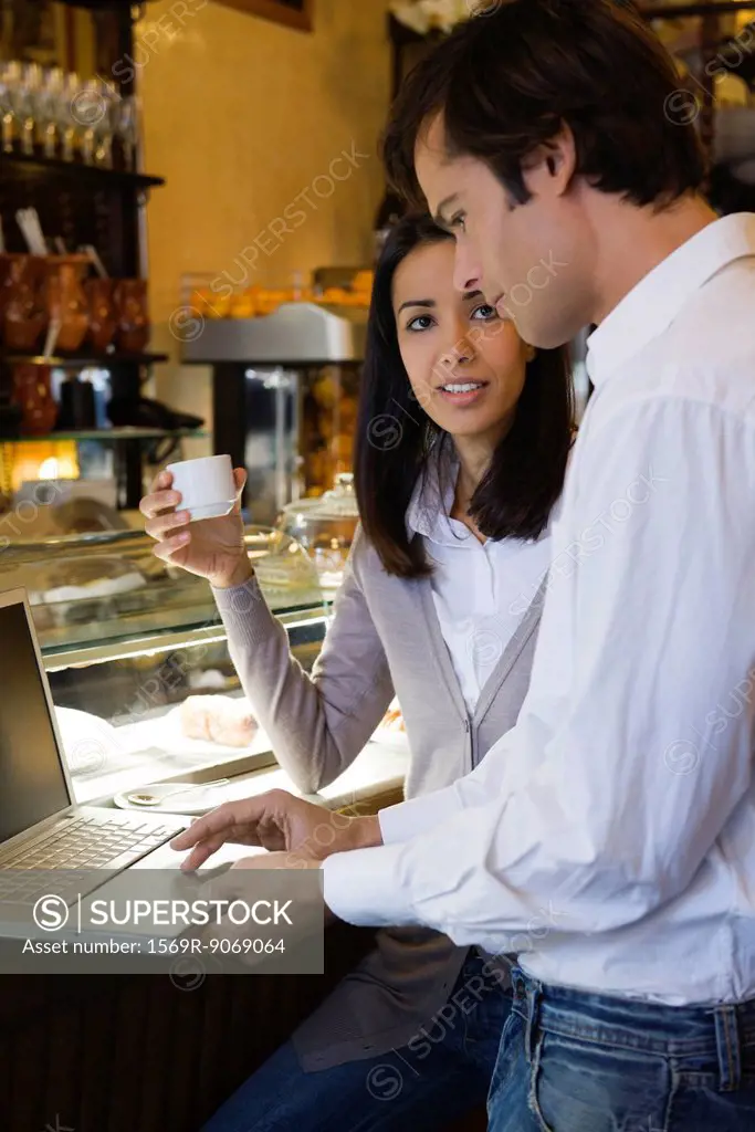 Couple using laptop computer in cafe