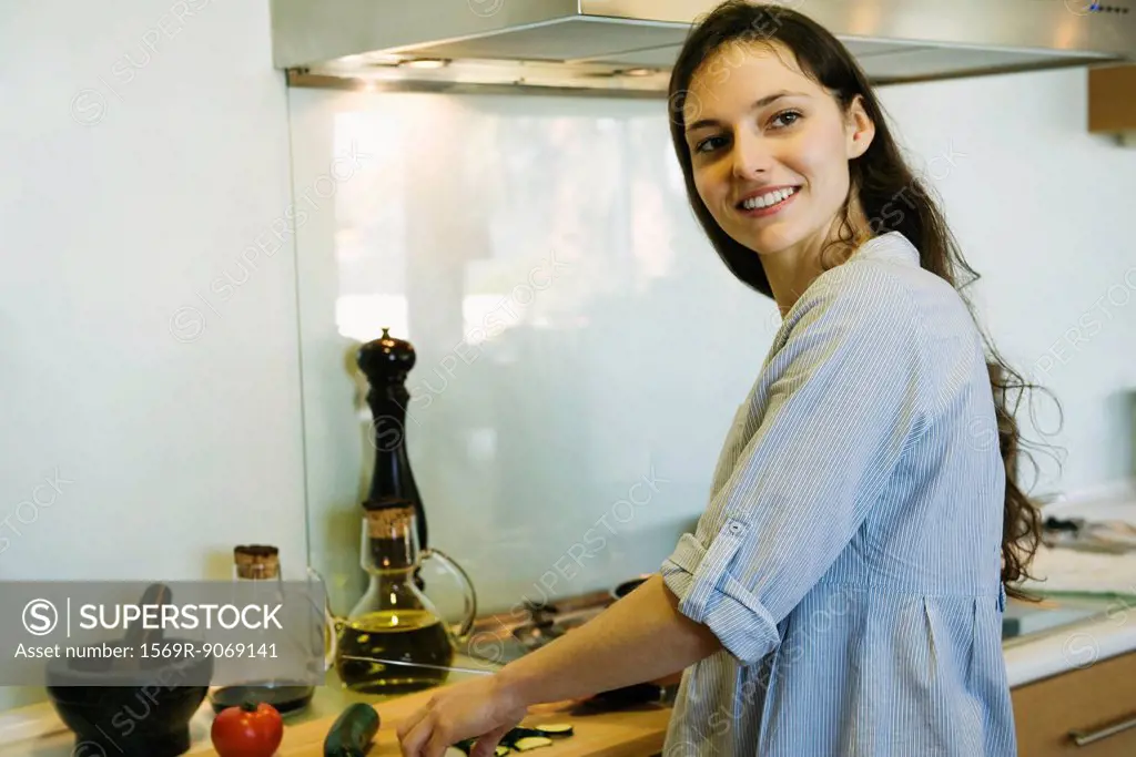 Woman cooking, smiling over shoulder, portrait