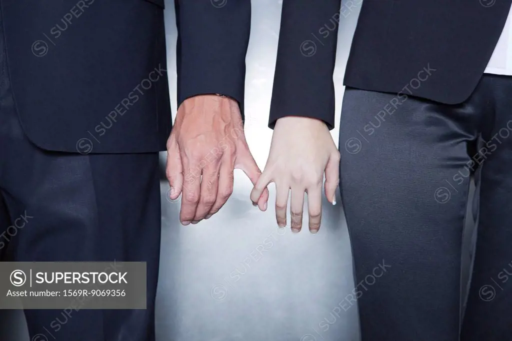 Professionals holding hands, cropped
