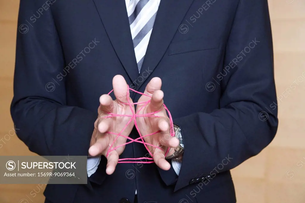 Businessman playing cat´s cradle with string