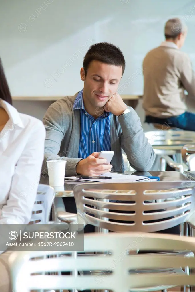 Man using cell phone in cafeteria