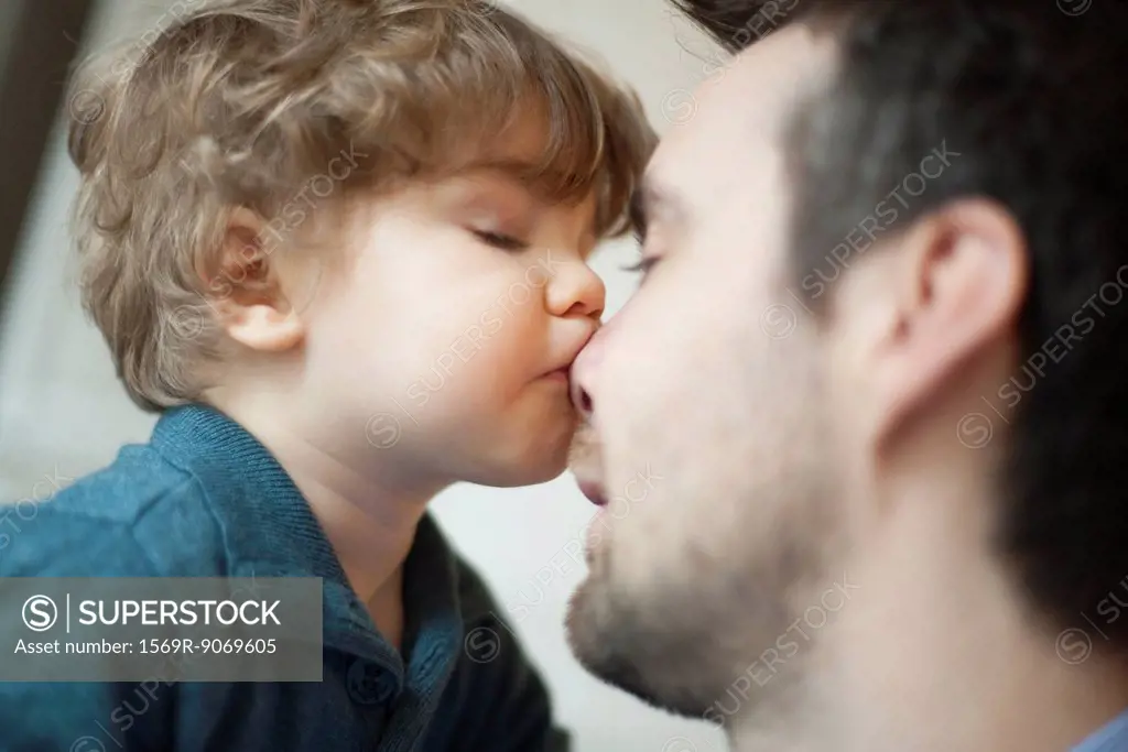 Toddler boy kissing father´s nose