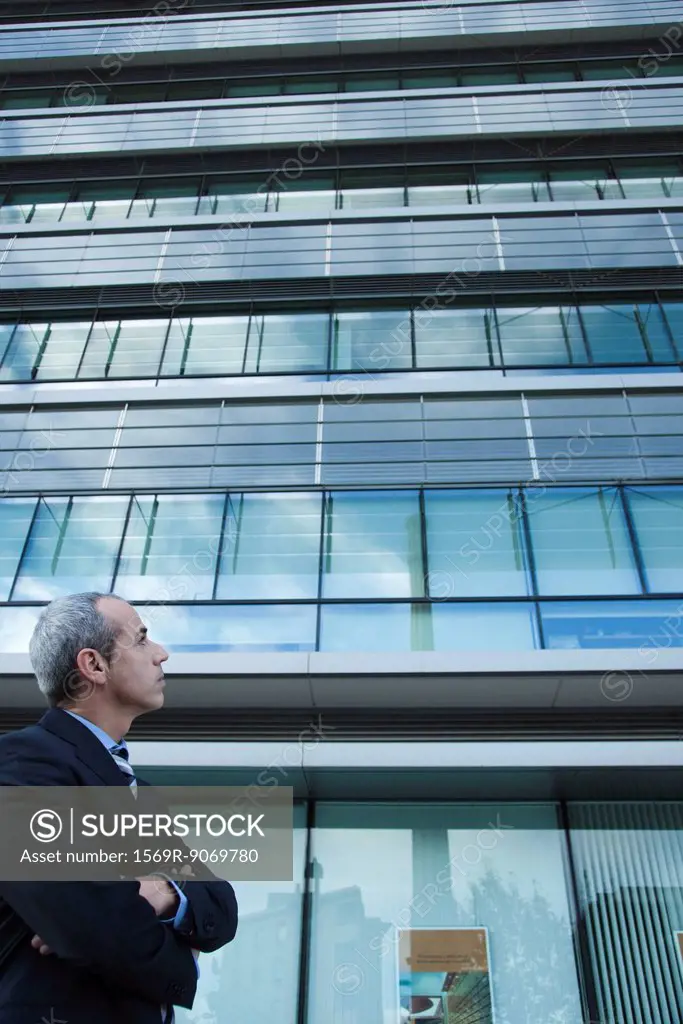Executive looking at office building in thought