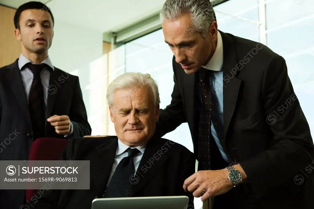 Executives looking down at digital tablet