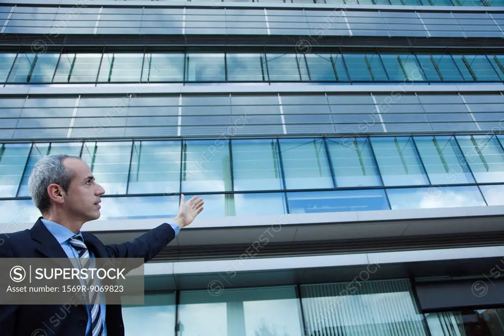 Executive gesturing at office building