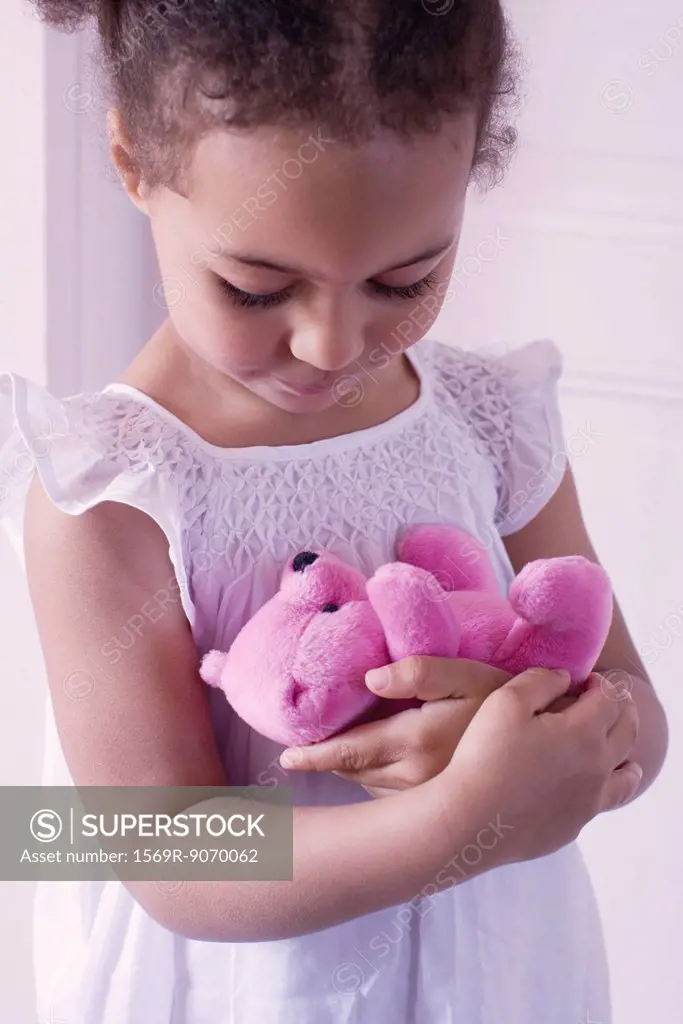 Little girl holding teddy bear affectionately