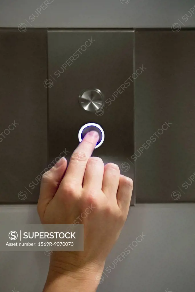 Woman´s finger pushing elevator´s down button