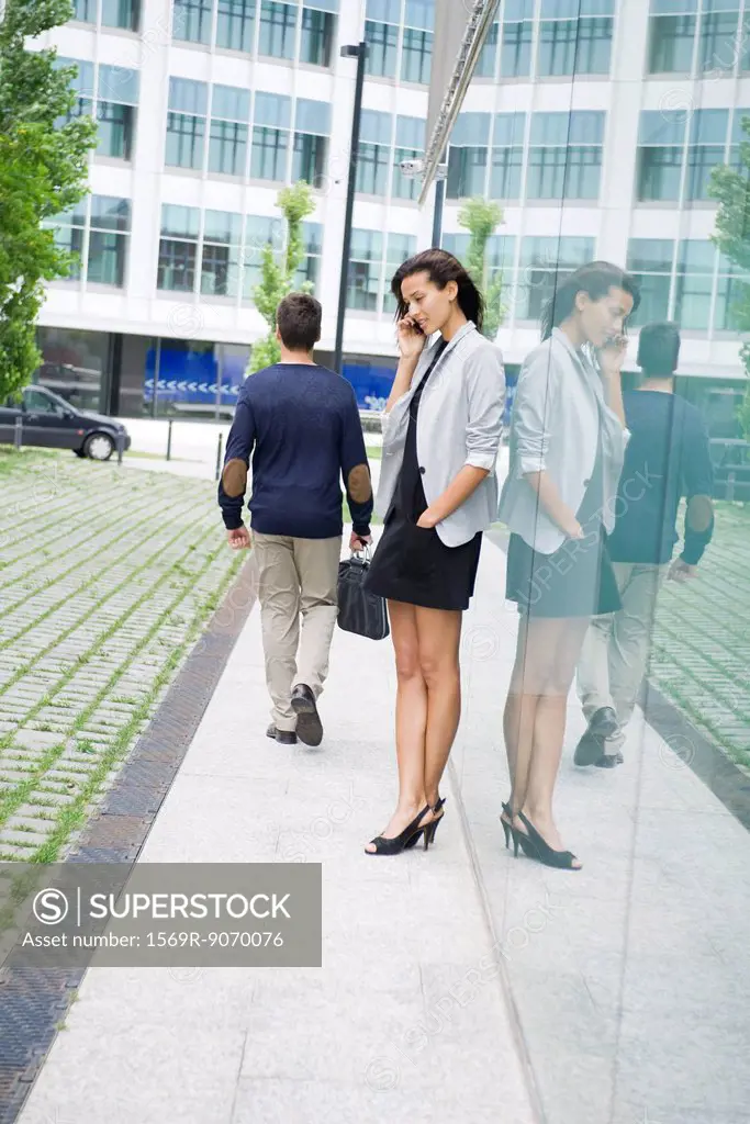 Businesswoman talking on cell phone outside of office building