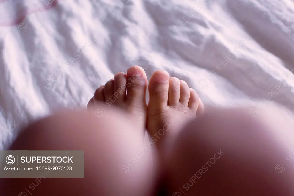 Foot of child on bed, low section